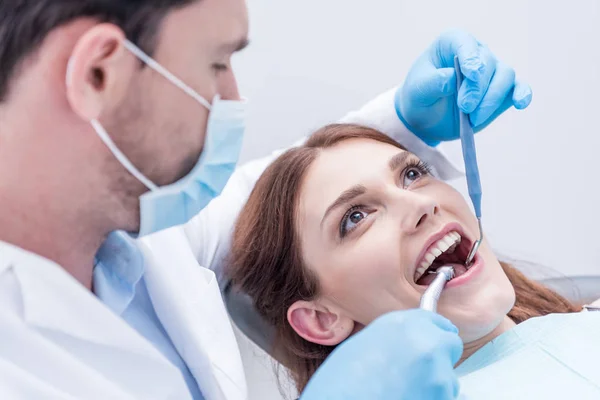 Dentiste guérir les dents des patients — Photo de stock