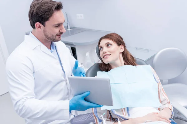 Zahnarzt diskutiert Behandlung mit Patient — Stockfoto