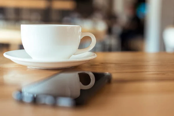 Taza de café en la mesa en la cafetería - foto de stock