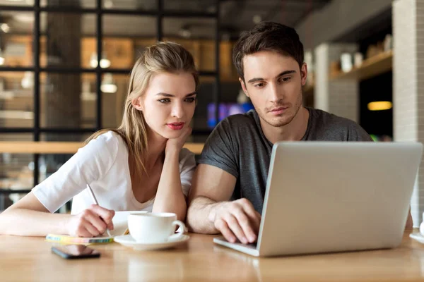 Couple travaillant sur ordinateur portable dans le café — Photo de stock