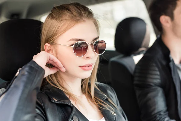 Donna elegante in occhiali da sole in auto — Foto stock