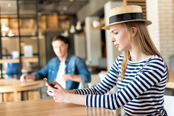 Mujer usando smartphone en la cafetería - foto de stock