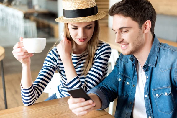 Couple using smartphone in cafe — Stock Photo