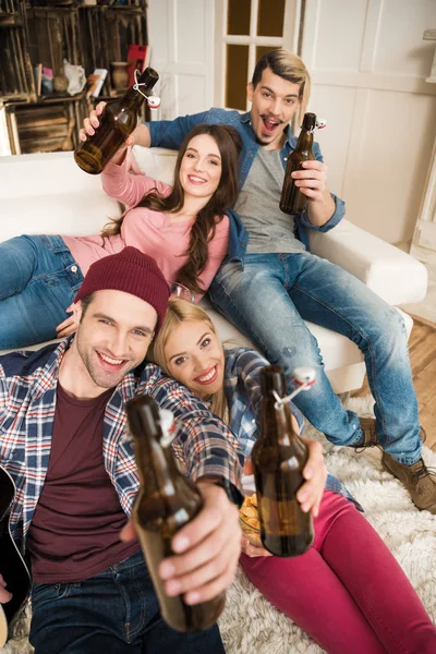 Giovani amici felici con bottiglie di birra — Foto stock