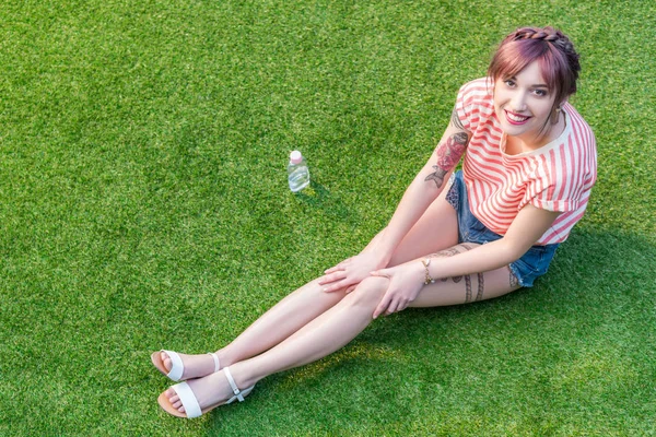 Jeune femme reposant sur l'herbe — Photo de stock