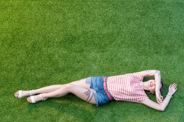 Junge Frau liegt auf Gras — Stockfoto