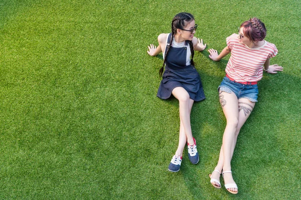 Multiethnic girls resting on grass — Stock Photo