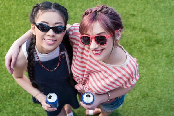 Chicas multiétnicas con latas de refresco - foto de stock
