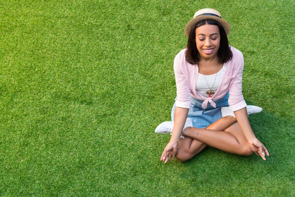 Africano americano chica meditando en hierba - foto de stock