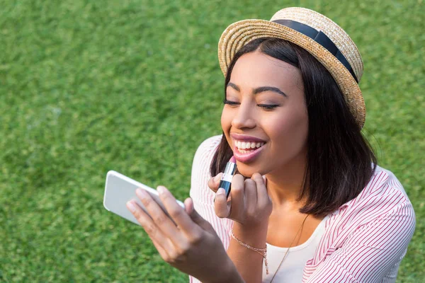African american girl applying makeup — Stock Photo
