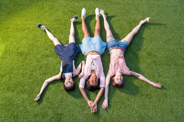 Meninas multiétnicas deitado na grama — Fotografia de Stock