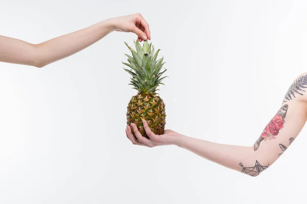 Mains féminines avec ananas — Photo de stock