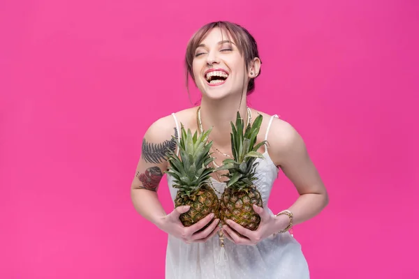 Jeune femme tenant des ananas — Photo de stock