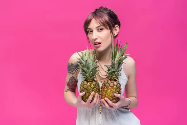 Jeune femme tenant des ananas — Photo de stock