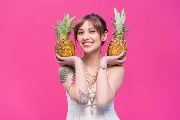 Jeune femme tenant des ananas — Photo de stock