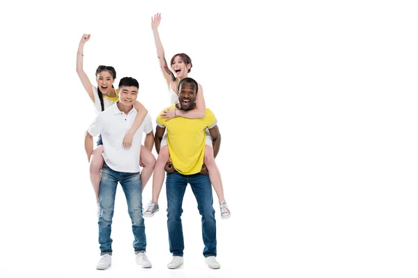 Multiethnic men piggybacking girls — Stock Photo