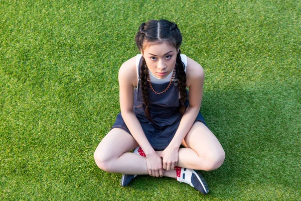 Asian girl sitting on grass — Stock Photo