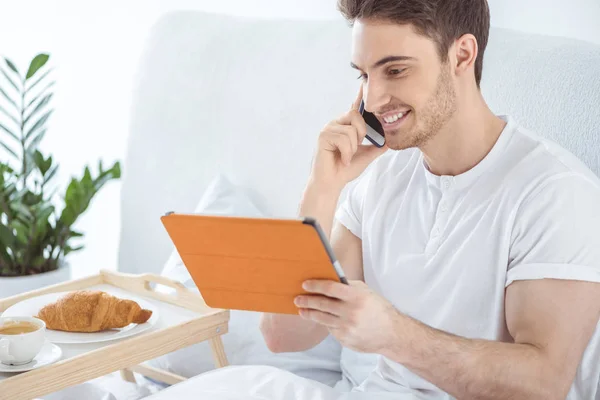 Homme avec tablette numérique et smartphone — Photo de stock