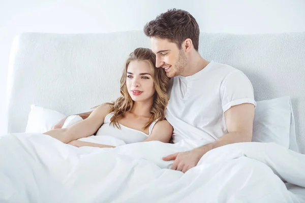 Pareja abrazándose en la cama - foto de stock