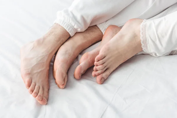 Ноги пары, лежащей в постели — стоковое фото