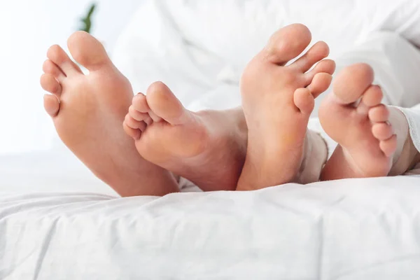 Feet of couple in bed — Stock Photo