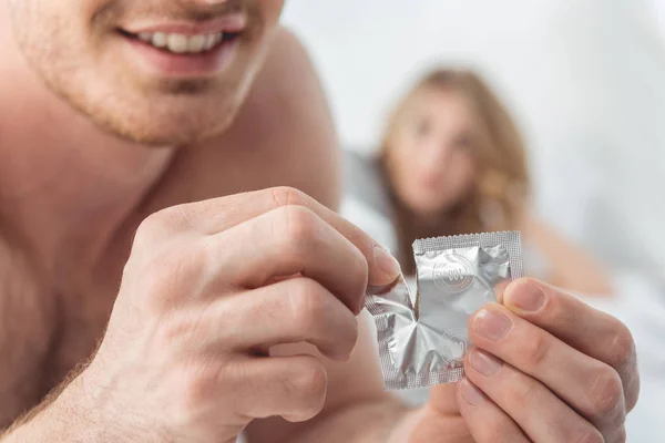 Man opening condom — Stock Photo