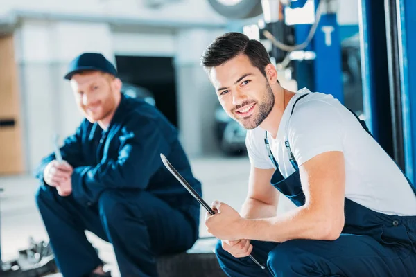 Automechanics sitting on floor — Stock Photo