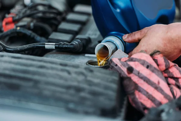 Automechanic changing motor oil — Stock Photo