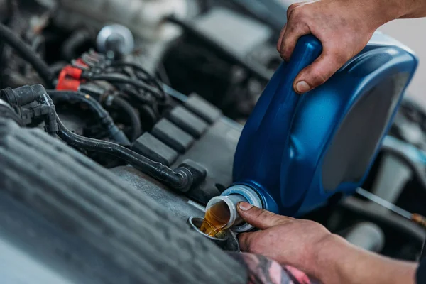 Automechanic changing motor oil — Stock Photo