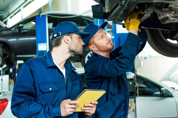 Automecánica trabajando en el coche - foto de stock