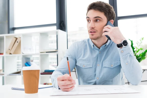 Architect with blueprint and smartphone — Stock Photo