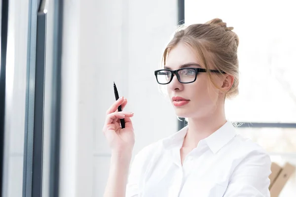 Thoughtful businesswoman in eyeglasses — Stock Photo