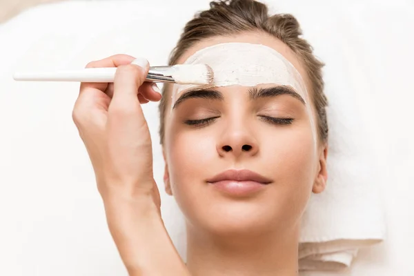 Cosmetologist applying facial mask — Stock Photo