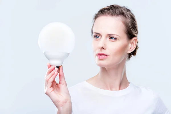 Femme concentrée avec ampoule — Photo de stock