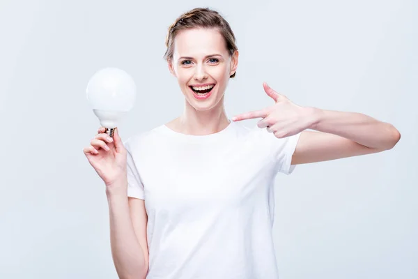 Woman pointing at light bulb — Stock Photo