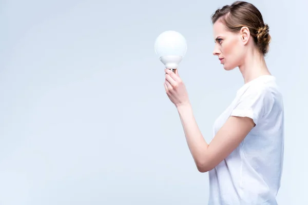 Сфокусированная женщина с лампочкой — стоковое фото