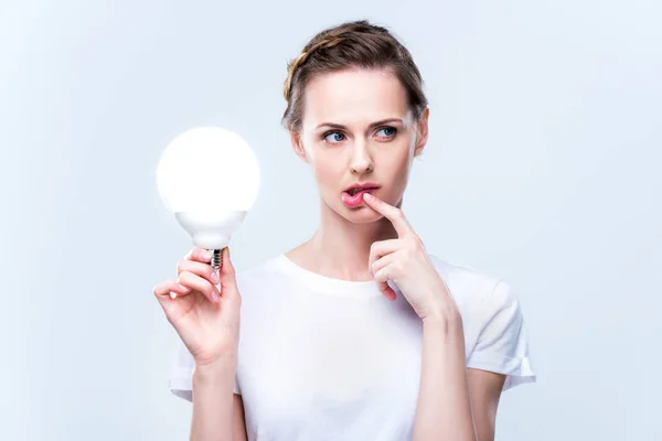 Femme réfléchie avec ampoule — Photo de stock