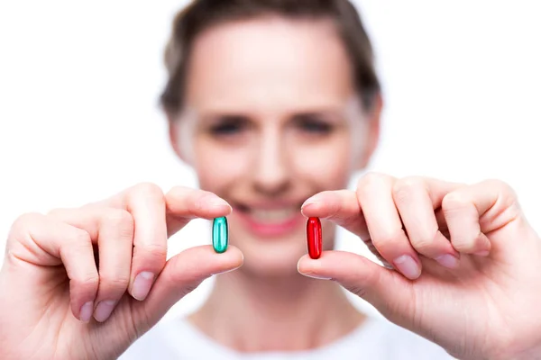 Mujer con píldoras rojas y azules - foto de stock