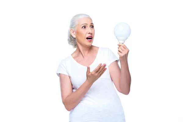 Mujer conmocionada con bombilla - foto de stock