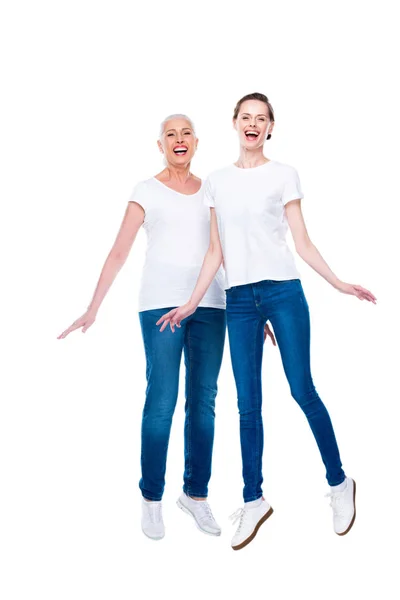 Jumping adult daughter and mother — Stock Photo