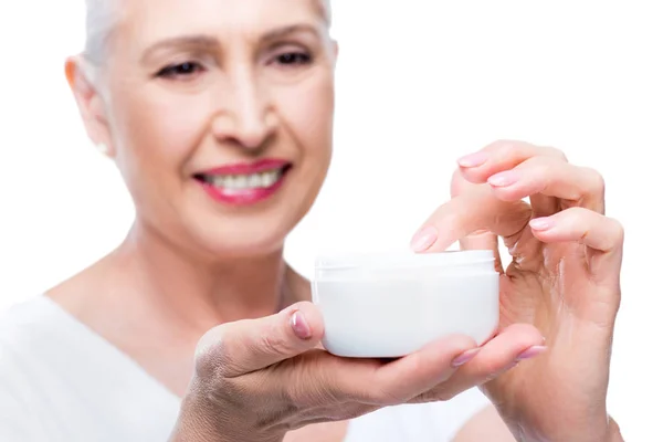 Femme âgée avec crème pour le visage — Photo de stock