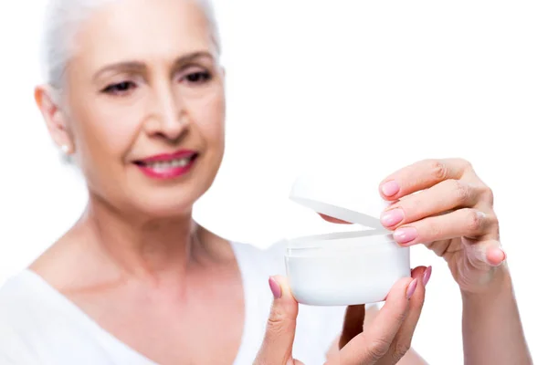 Mujer mayor con crema anti-arrugas - foto de stock