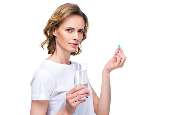 Mujer con vaso de agua y píldora - foto de stock