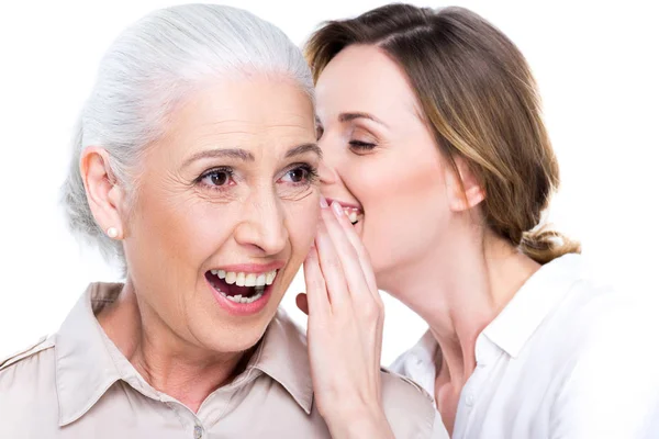 Daughter whispering to senior mother — Stock Photo