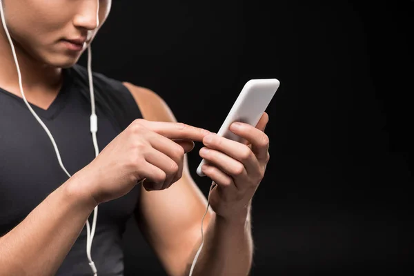 Homme dans les écouteurs utilisant un smartphone — Photo de stock