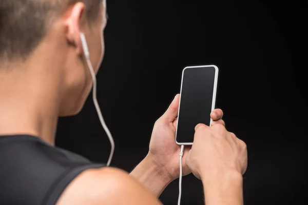 Man in earphones using smartphone — Stock Photo