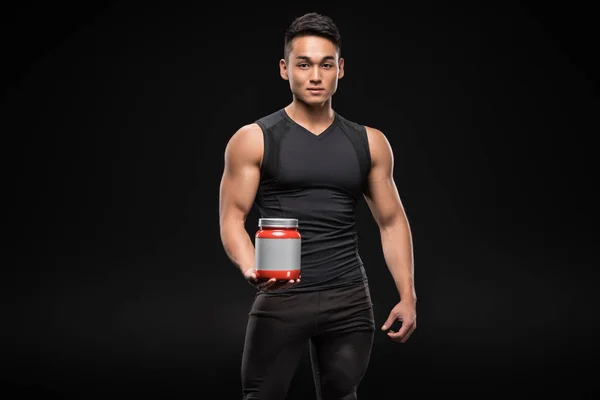 Homme musclé avec nutrition sportive — Photo de stock