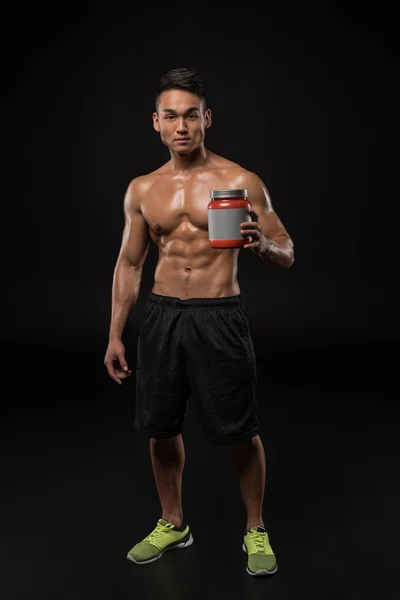 Muscular man with sport nutrition — Stock Photo