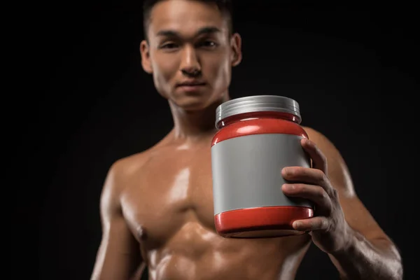 Homme musclé avec nutrition sportive — Photo de stock