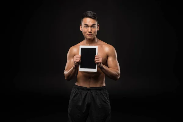 Homme musculaire avec tablette numérique — Photo de stock